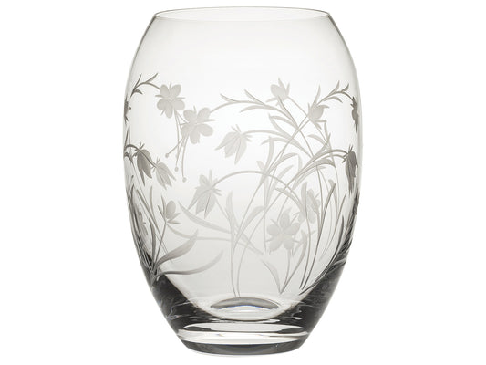 A barrel shaped crystal vase with a delicate floral motif of entwining wildflowers cut into the exterior, giving the motif a frosted appearance.