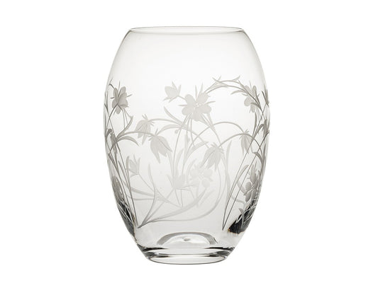 A small crystal barrel vase with a wildflower pattern cut into the outside, with twisting stems and delicate flowers in a frosted effect.