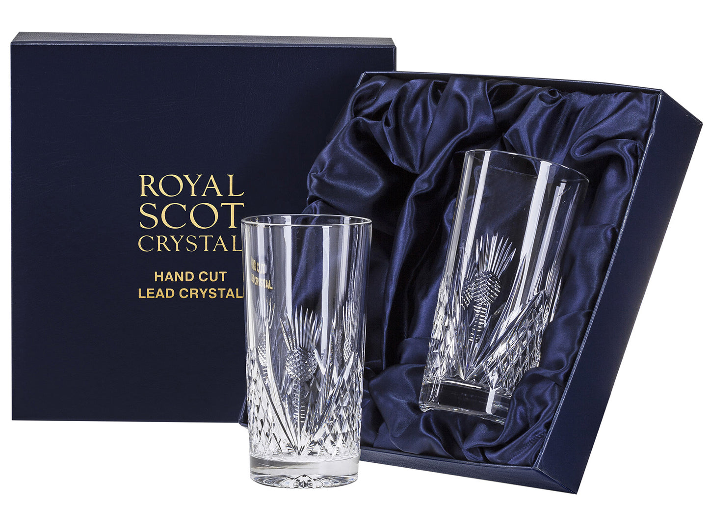 A pair of crystal highball glasses with a Scottish thistle cut into the exterior of the glass, surrounded by a diamond pattern around the base. They come in a navy-blue silk-lined presentation box with gold branding on the lid.