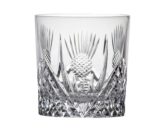 A straight-edged crystal whisky glass with a scottish thistle design around the outside