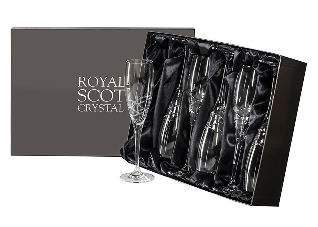 A set of six matching champagne flutes with long stems and a delicate orbital pattern cut above the stem. They come in a slate-grey silk-lined presentation box with silver branding on the lid.