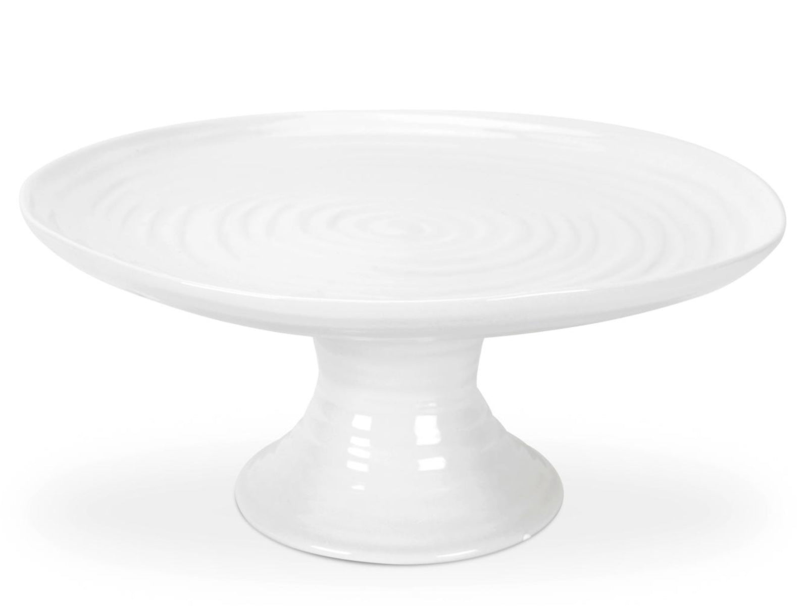 A white porcelain cake stand with a tall foot and rippled texture